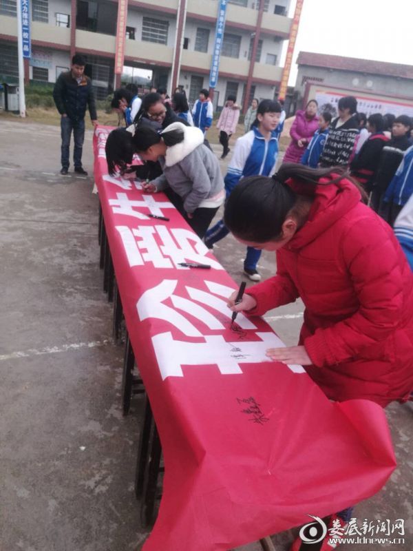 九年级学生正在认真签下自己的名字