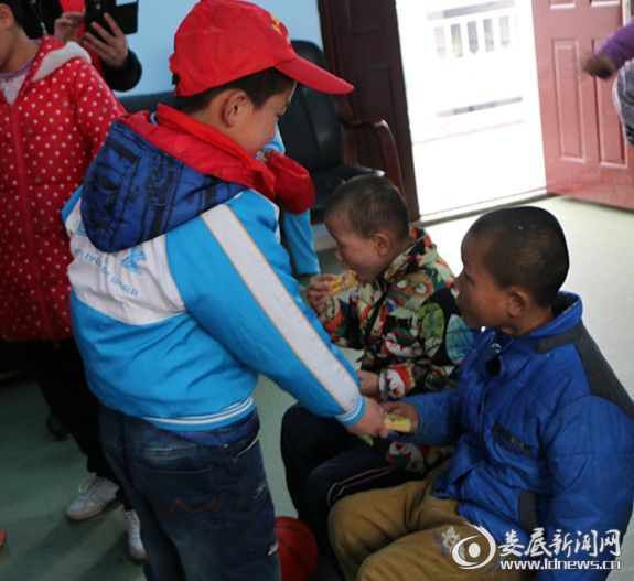 3、红领巾志愿者给福利院的孩子分饼干