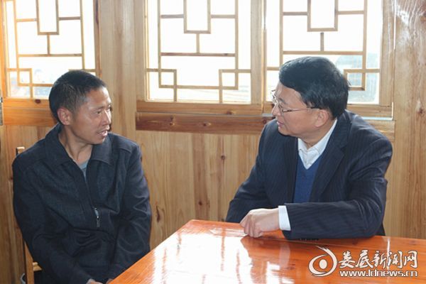 在贫困户刘忠荣家中，何文君与其亲切交谈