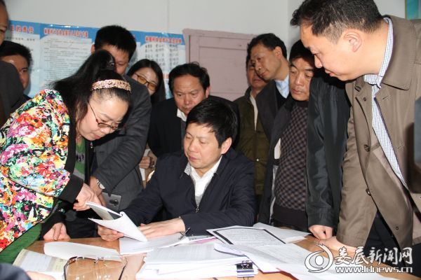 图为徐勇（前排中）在新化县维山乡林屋村向驻点审计人员了解村财务开支情况