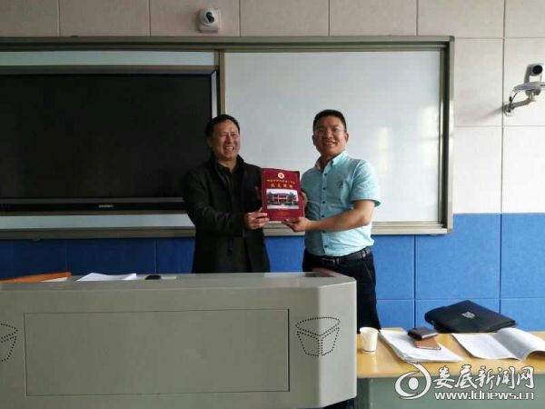 曹光辉书记将新化一中校友联络手册赠送给校友代表刘登明先生