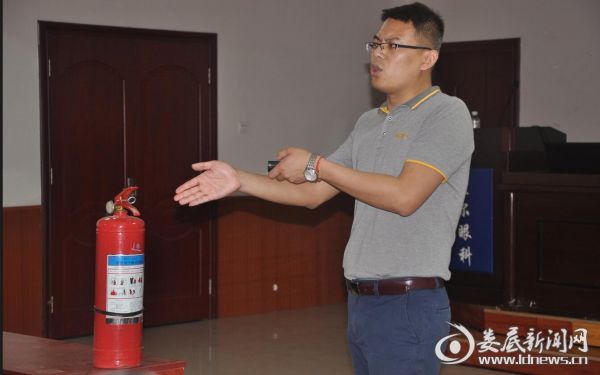 张教官示范、指导灭火器的正确使用方法