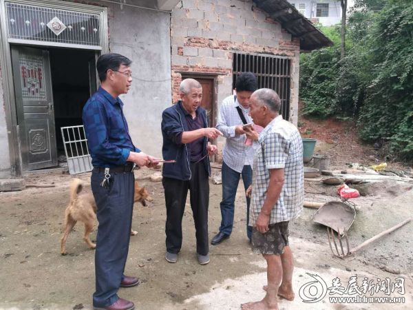 工会主席管长元（左一）正在慰问贫困村民