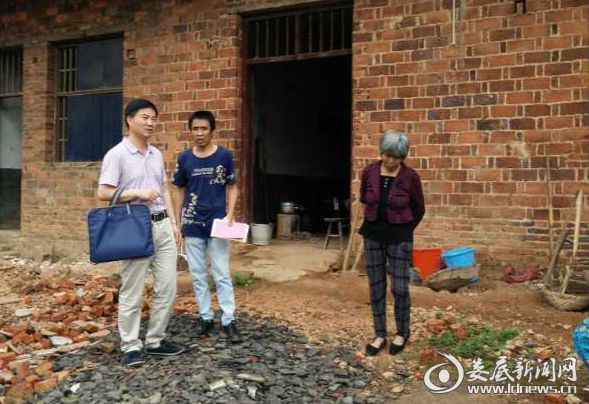 罗建国书记（左一）与村民交流，详细了解其家庭情况