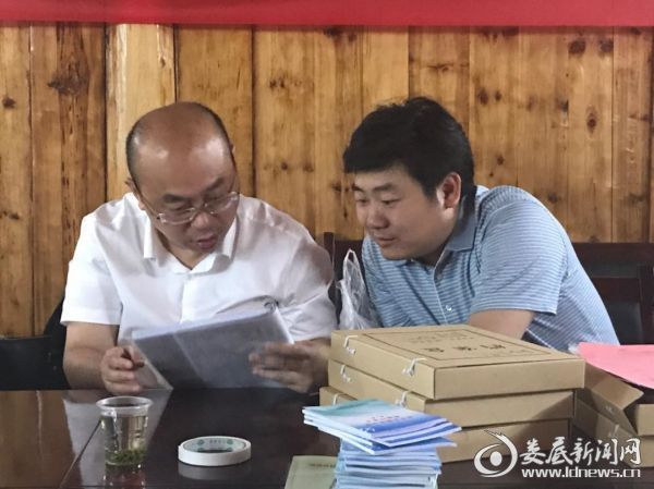邓伟在浪山坪村仔细查看脱贫攻坚资料