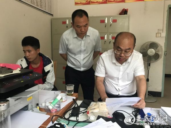 邓伟在镇扶贫站查看脱贫攻坚相关资料