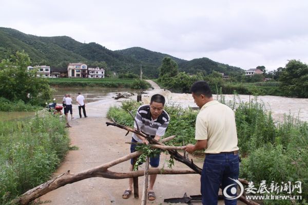 7月1日下午，丰华村邹家坝被大水淹没，乡村干部在设置临时警示标志