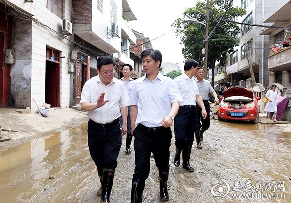穿着雨鞋，踩着淤泥，李荐国在老街一边走，一边查看、了解灾情
