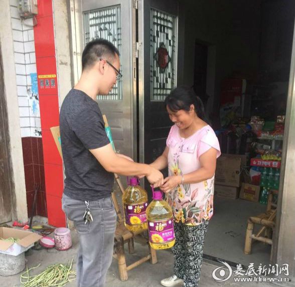 扶贫队员汪双平给残疾贫困人送油