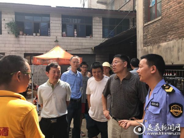 吴公平副局长（右二）在娄底市食药监局局长侯迪凡（左二）的陪同下走访受灾的食品药品生产经营户