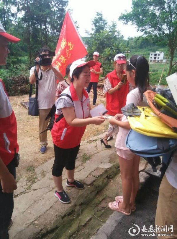 湘中社区志愿者服务队队长把爱心捐款和书包等物品交给孩子们1_看图王