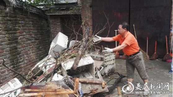 市供销社办公室主任李利民正在搬运垃圾