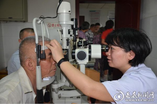 娄底爱尔眼科医院廖圣医生正在为白内障术后患者检查恢复情况