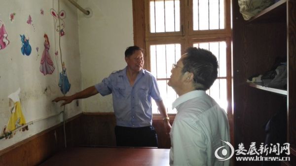受灾职工谢国河（左）介绍房屋被淹情况