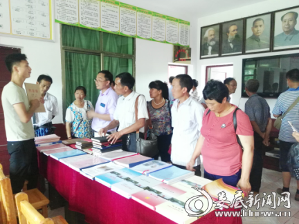 参观团参观村里脱贫攻坚相关资料。