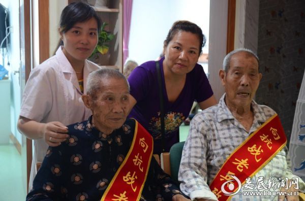 李伯余(左)和唐超群（右）两位抗战老兵与工作人员合影