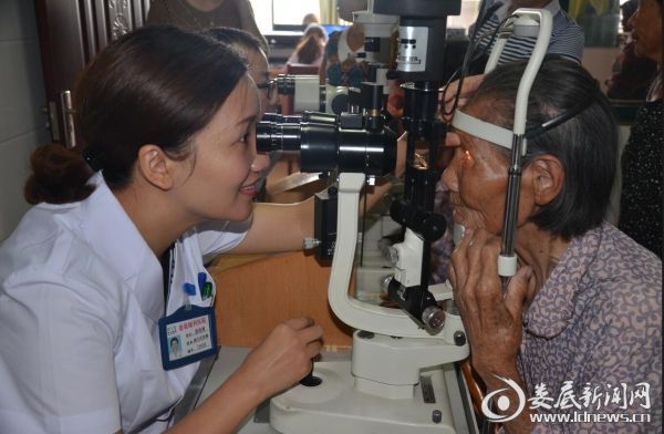娄底爱尔眼科医院眼底病中心主任、民盟娄底眼科医院支部组织委员唐玖鸿为患者复查术后情况