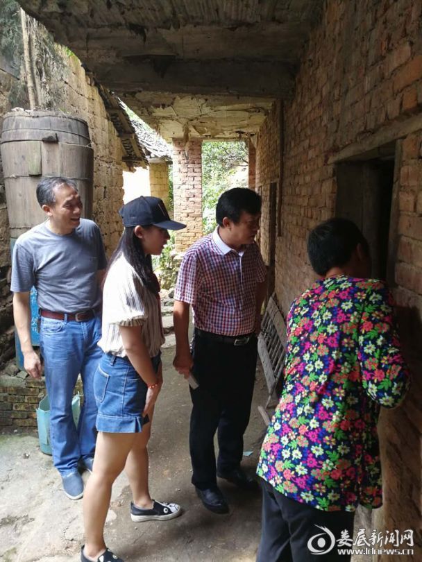 （谭平贵一行（左三）来到贫困户曾建候家慰问）