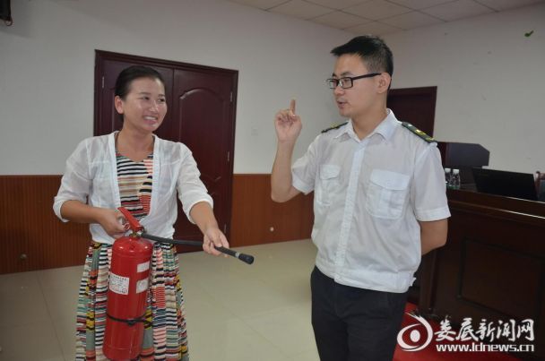 消防安全指导老师教现场学员如何使用干粉灭火器