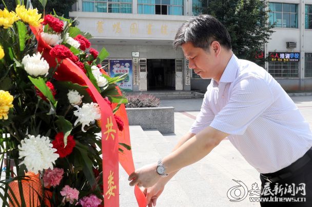 李荐国向“蔡和森同志光辉一家”敬献花篮，并仔细整理花篮上的缎带