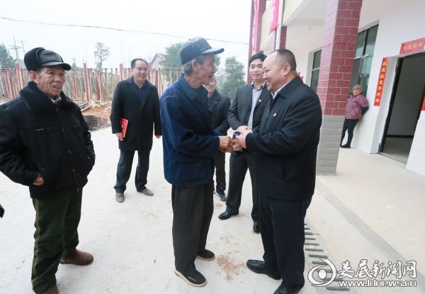 党委书记倪志铭将钥匙交到贫困住户的手中