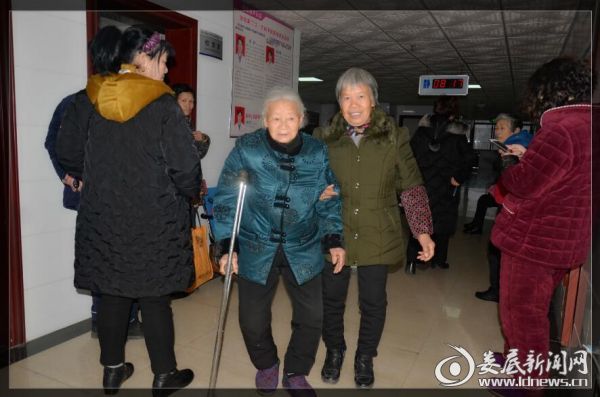 谢春贞老人在家人搀扶下准备出院