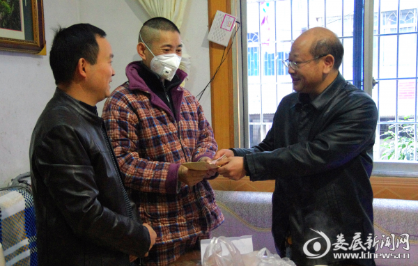 杨理斌把慰问金交到熊美祥手上