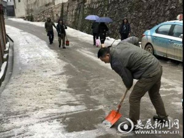 （娄底市救助管理站工作人员清理站外道路积雪）