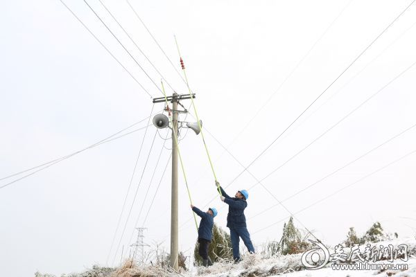 图为国网娄底供电公司城北供电所电力工人肖利、吴运松挥舞除冰棒，在为线路除冰。（肖璋 摄）