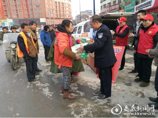 (图为县救助站站长周鹏为流浪阿姨发放爱心泡面)
