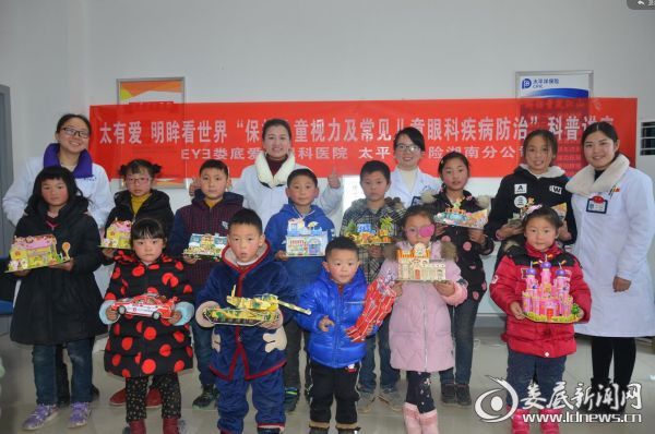娄底爱尔眼科医院视光团队工作人员与拼图成型的孩子们合影