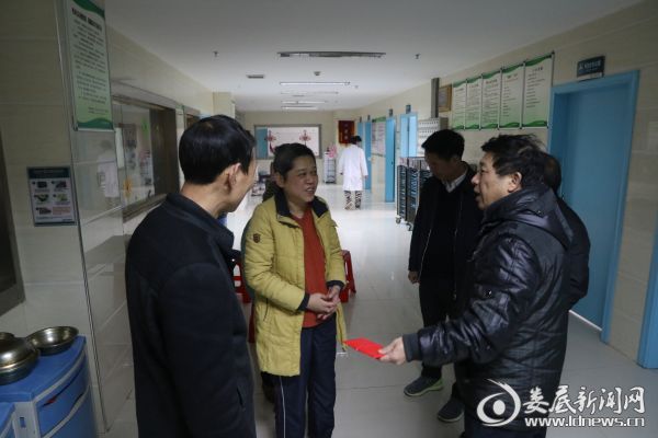 市卫生计生委工会负责人、调研员吴小平（右一）和市卫生计生协会副秘书长肖升红（左一）将5000元特困扶助金送到胡朝晖手中