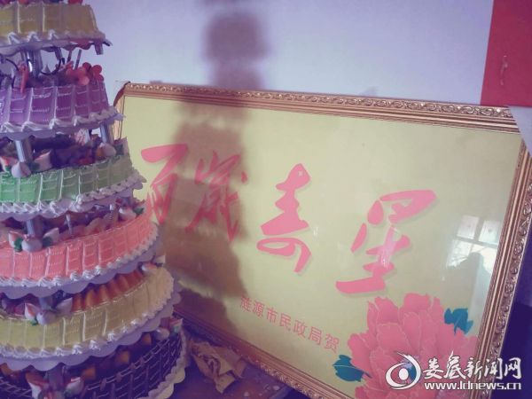 （为老人送上“百岁寿星”牌匾）