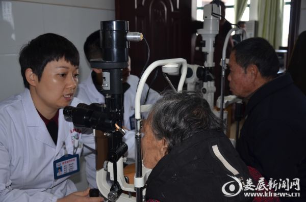 娄底爱尔眼科医院医务科科长曾海平为老人检查术后情况