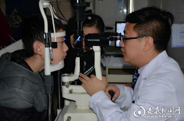 陈兆为参加活动的孩子进行检查