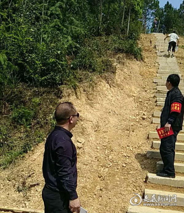 镇村干部正在万宝镇福善村沿山巡逻