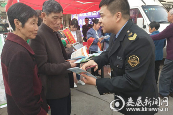 (工作人员分发宣传资料讲解食药安全知识)