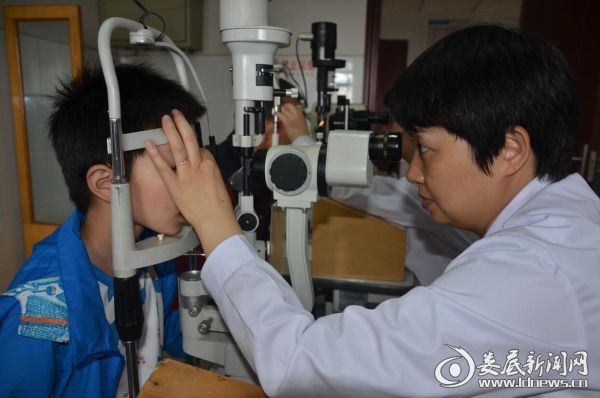 娄底爱尔眼科医院医务科科长曾海平为张伟铭小朋友做术前检查