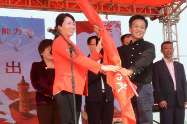 (双峰县委副书记杨萍为文艺队授旗)