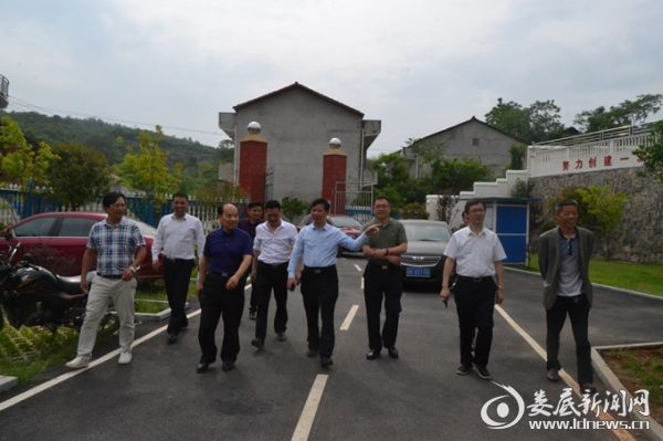 （双峰县领导考察石头山上“敲”出来的群建小学)）