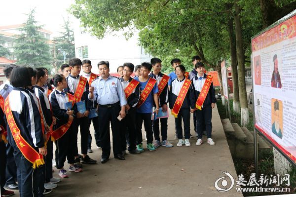（在税法宣传栏前，涟源地税局局长扶新明向广大学生讲述了税法典型故事，鼓励大家好好学习，报效国家，将来做诚信纳税的好公民）