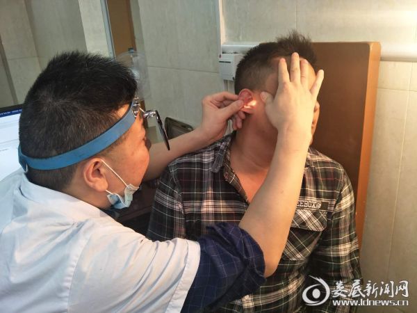 51病室主任李泉为患者检查耳部