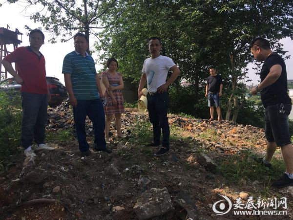 三级河长负责人察看固体废弃物堆放点
