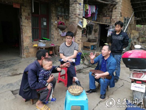图为民政局干部帮助贫困户制定脱贫计划