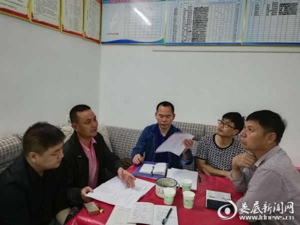 图为民政局党组成员袁健平（左三）在听取汇报