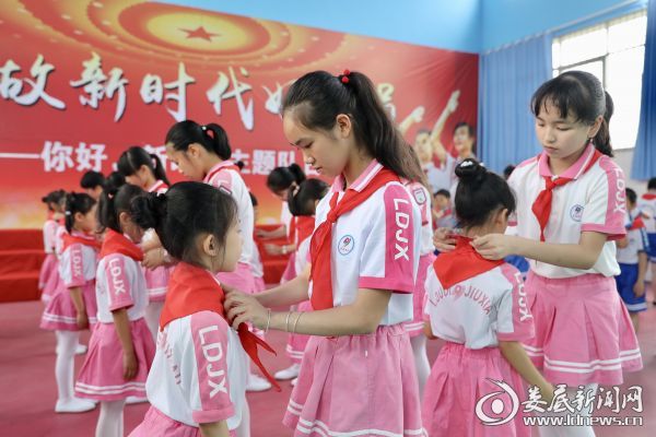 老队员为新队员佩戴红领巾