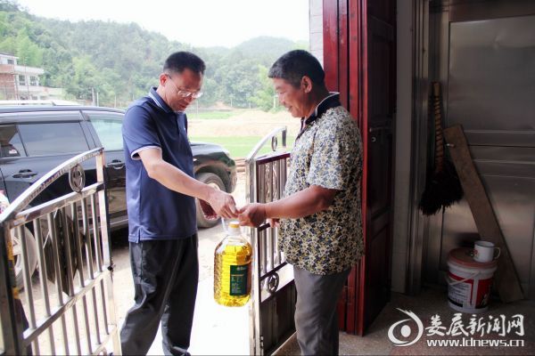 图为邓志洪（左一）走访慰问贫困户