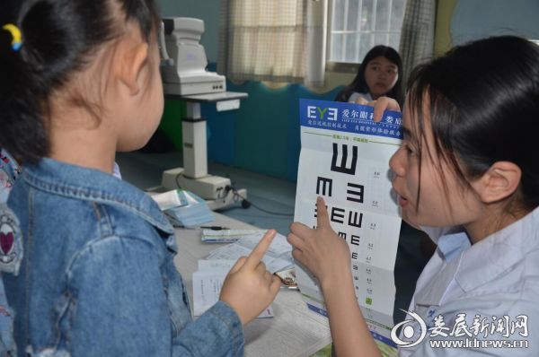娄底爱尔眼科医院义务人员耐心指导孩子们正确识别视力表
