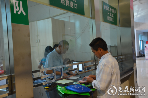 （贫困患者在便捷的结算窗口前清点报销现金）