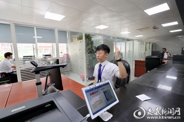 市政务服务中心窗口工作人员向下一个办理业务的市民举手示意